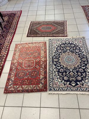 Plusieurs tapis sont disposés sur le sol carrelé d'une pièce