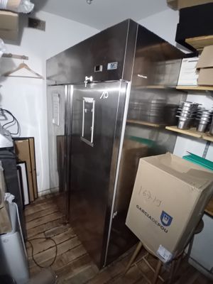 une photo d'un réfrigérateur dans une cuisine, avec une boîte posée devant