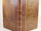 un vieux livre à la couverture brune posé sur une table
