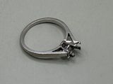une bague en argent ornée d'un oiseau, posée sur une table
