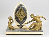une statue représentant un homme et une femme jouant avec une horloge