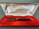 a close up of a pen in a red box on a table