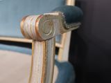 a close up of a blue chair with a wooden arm