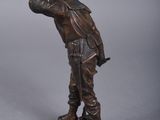 bronze figurine of a man with a gun on a base