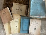 plusieurs vieux livres posés sur un plancher en bois, à côté d'une botte de foin