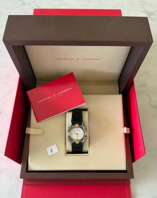an open box with a watch inside of it on a marble surface