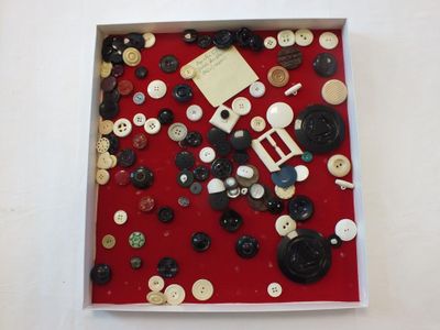 une photo d'une boîte de boutons posée sur une table