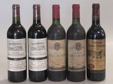 several bottles of wine are lined up on a white surface