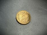 a gold coin sitting on top of a gray surface