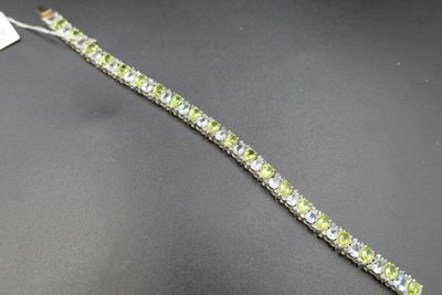 un gros plan d'un bracelet vert et blanc posé sur une surface noire