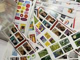 a pile of stamps on a table with a bag of them