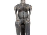 an image of a statue of a woman sitting on a stool