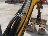 a yellow and black excavator that is sitting on a pallet