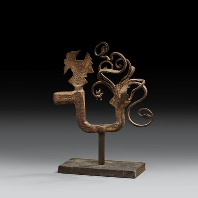 une sculpture en bronze représentant un oiseau et une fleur, posée sur un socle