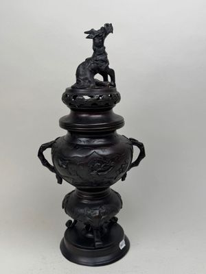 une urne noire surmontée d'un oiseau