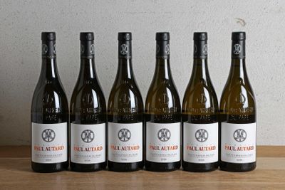 six bouteilles de vin sont alignées sur une table en bois