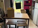 une cuisine avec une table et quatre tabourets à l'intérieur