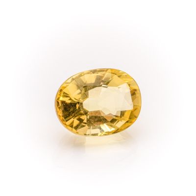 a yellow sapphire stone on a white background