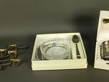 a glass bowl and spoon in a box with a spoon and spoon rest