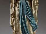 statue d'une femme vêtue d'une robe bleue, tenant un chapelet entre ses mains