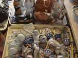 a table with a tray of pottery and a tray of figurines on it