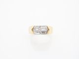 an 18k yellow gold ring set with a baguet cut diamond