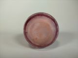 a close up of a pink vase on a white surface