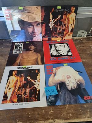 Les pochettes d'albums des Rolling Stones sont posées sur une table en bois