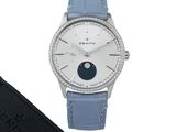 une image d'une montre-bracelet avec un bracelet bleu et un cadran argenté en forme de lune