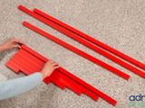 someone is cutting red strips on the floor with a pair of scissors
