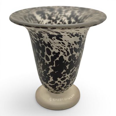 un vase noir et blanc posé sur un socle