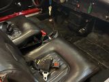 the interior of a red car with black leather seats and a steering wheel