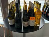 many bottles of wine sitting on a table in front of a window