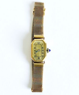 une montre posée sur une surface blanche