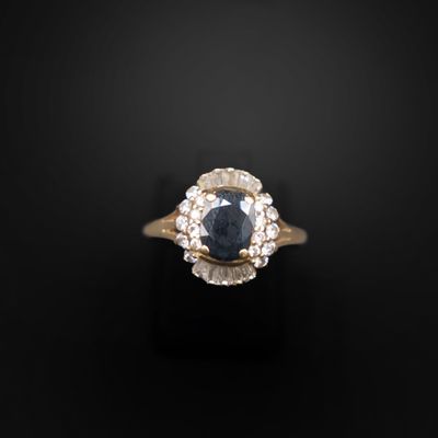 un gros plan d'une bague sertie d'un saphir bleu et de diamants blancs