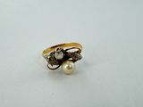 a close up of a ring with pearls on a white surface