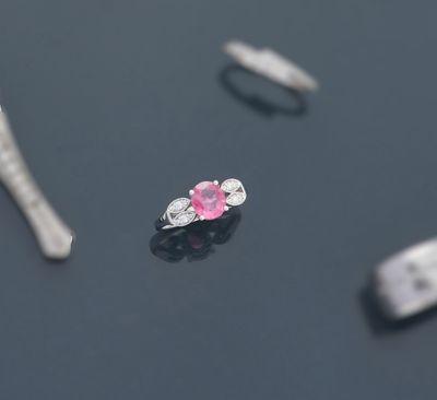 quelques diamants roses et blancs sont posés sur une surface noire