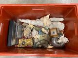 a red container filled with assorted items on the floor