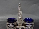 two blue glass cups sitting on top of a silver stand