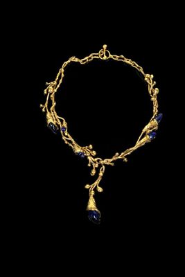 a gold and lapis necklace with a blue stone pendant