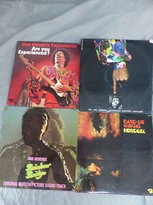 Quatre pochettes d'albums différentes des Rolling Stones sont posées sur un lit