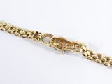 a close up of a gold watch with a chain around it