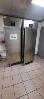 un réfrigérateur argenté dans une cuisine dont le sol est recouvert de carrelage