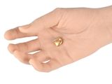 a hand holding a small heart shaped object in it ' s palm