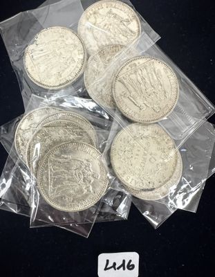 plusieurs pièces d'argent dans des sachets en plastique posées sur une surface noire
