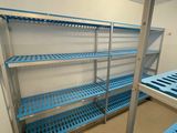 une étagère bleue au milieu d'une pièce remplie d'étagères