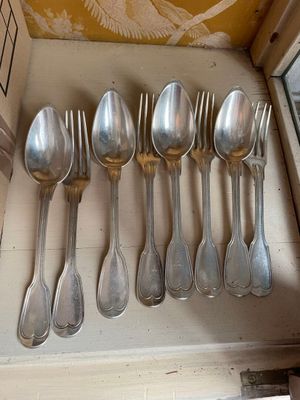 a lot of silver spoons and spoon spoons on a shelf