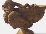 a wooden vase with a bird on top of it