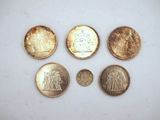 a group of five different coins sitting on top of a white surface