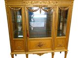 une vitrine dorée avec des portes vitrées et un miroir